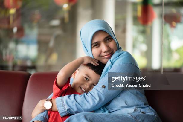 mother and toddler son - headscarf home stockfoto's en -beelden