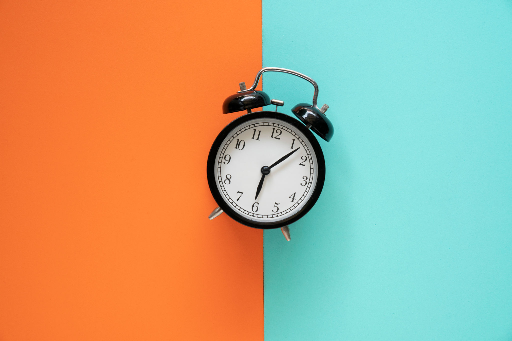 Retro alarm clock on color table background, vintage style Retro alarm clock on color table background, vintage style