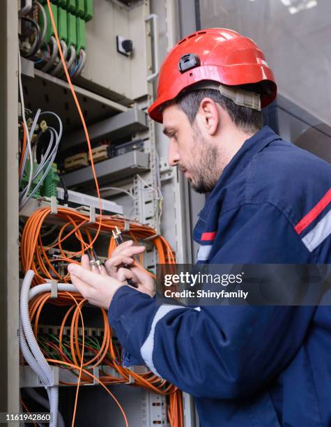 ingenieur, der glasfaserkabel an den schalter anzuschließen - handwerker weißer helm stock-fotos und bilder