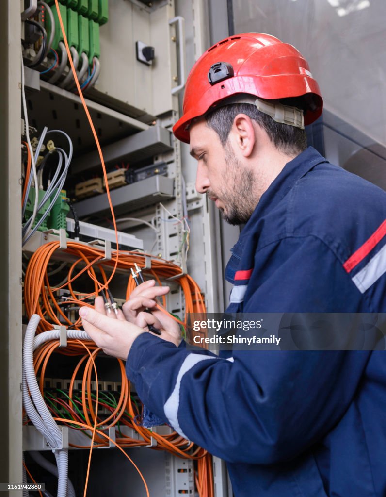 Engineer connecting fiber optic cable to the switch