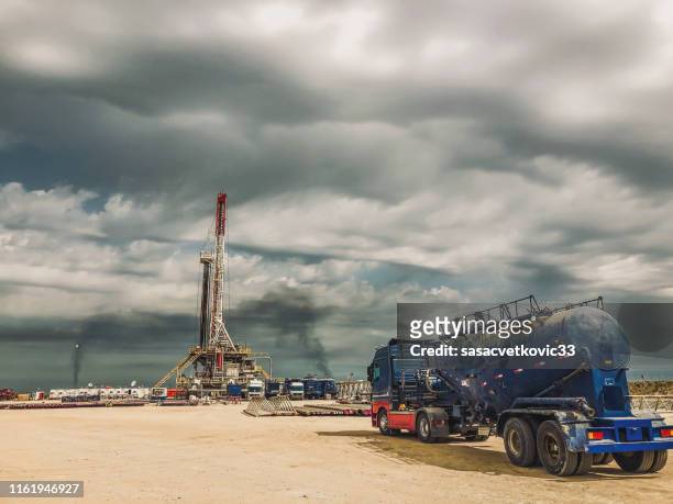 rig d'huile de fracturation au coucher du soleil - gisement de pétrole photos et images de collection
