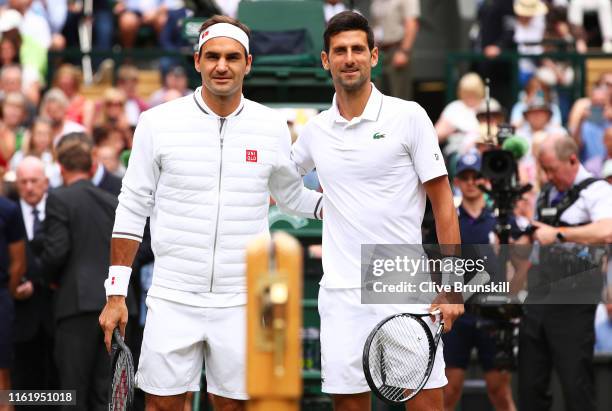 Novak Djokovic of Serbia and Roger Federer of Switzerland pose for a photo at the net prior to their Men's Singles final during Day thirteen of The...