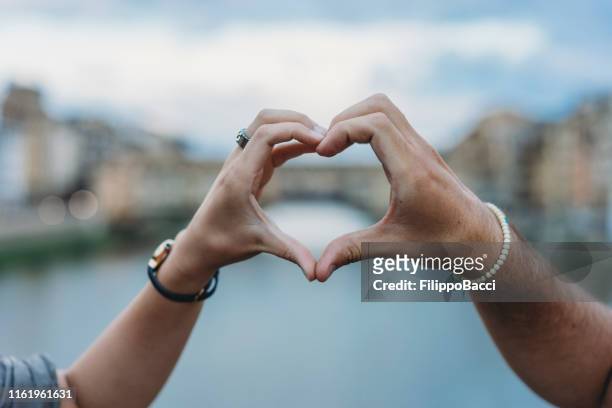 herzformsymbol mit händen in florenz, italien - two hearts stock-fotos und bilder