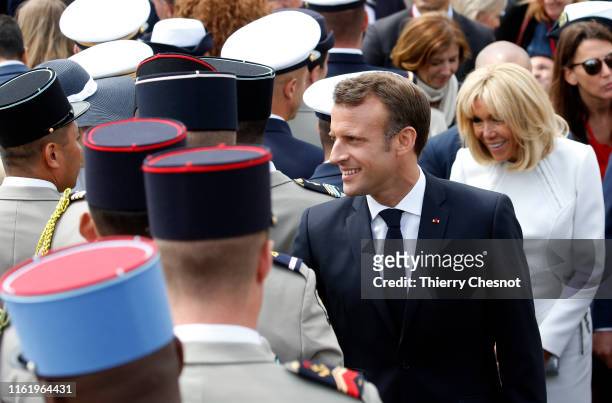 French President Emmanuel Macron and his wife Brigitte Macron greet toops and guests after the traditional Bastille Day military parade on the...