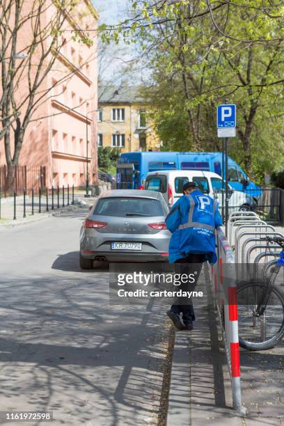 parking attendant monitors a parked car, krakow, poland - krakow park stock pictures, royalty-free photos & images