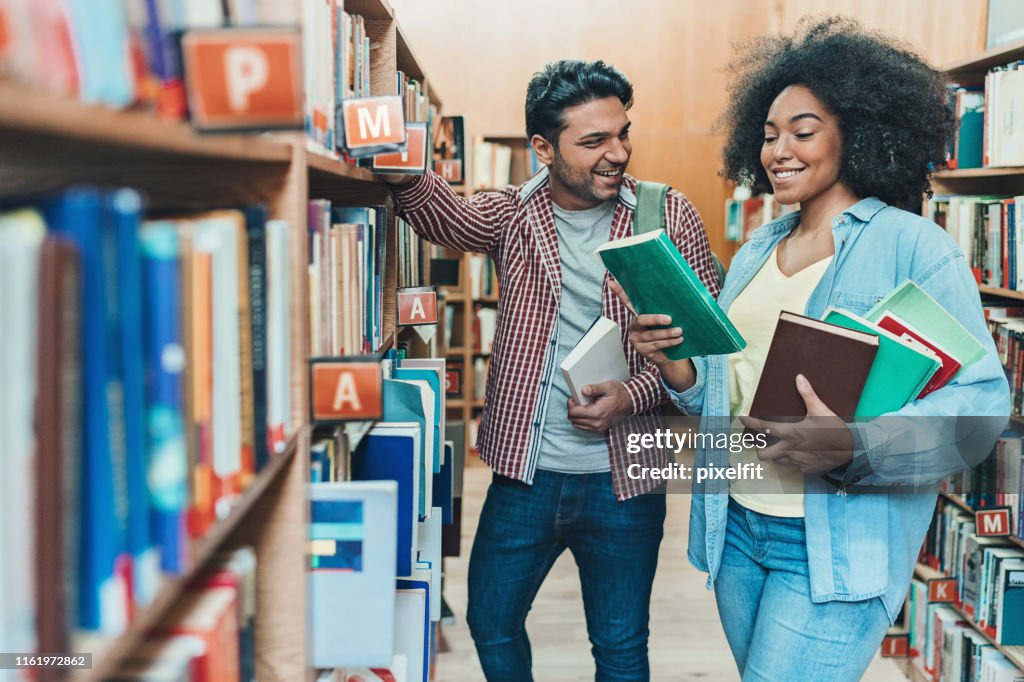 Talking In The Library Two Students Talking In The Library High-Res Stock Photo - Getty Images