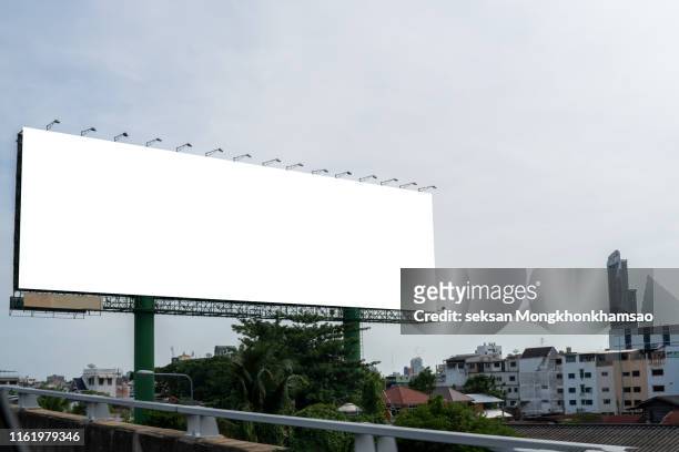 low angle view of billboard against clear blue sky - billboard bus stockfoto's en -beelden