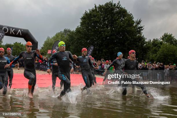 Athlete Eneko Llanos of Spain and Josh Amberger of Australia amid others start the swim leg of Ironman Vitoria on July 14, 2019 near Vitoria, Spain.