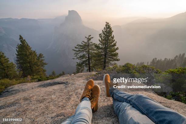 perspectiva personal de la pareja relajarse en la cima del valle de yosemite; vista de pies - parque nacional fotografías e imágenes de stock