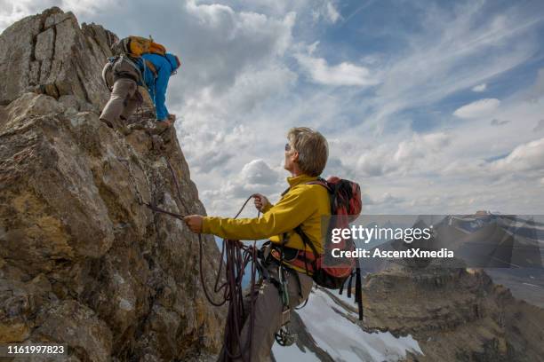 two climbers explore mountain ridge above a glacier - belaying stock pictures, royalty-free photos & images