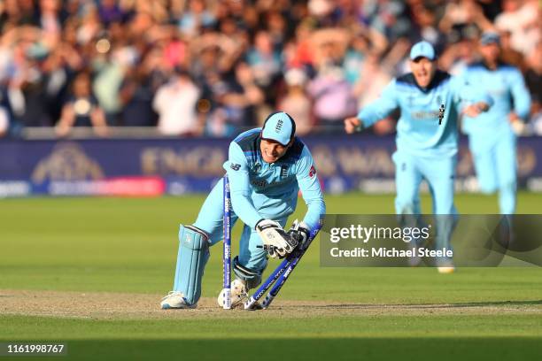 Jos Buttler of England runs out Martin Guptill of New Zealand to seal victory for England during the Final of the ICC Cricket World Cup 2019 between...