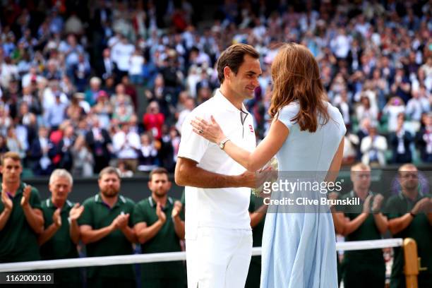 Roger Federer of Switzerland is presented with the runners-up trophy by Catherine Duchess of Cambridge after his Men's Singles final against Novak...