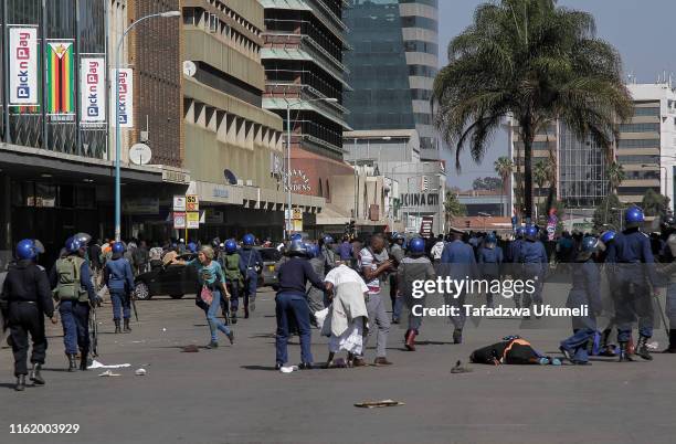 Injured demonstrators lie in the street as the protest is driven back by riot police on August 16, 2019 in Harare, Zimbabwe. The country's main...