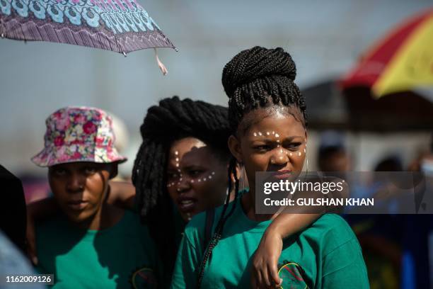 Women look on as they take part in a gathering on Wonderkop in Marikana, Rustenburg, where striking miners were killed during the Marikana Massacre,...