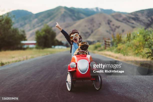 junge und hund in spielzeug racing car - positive emotionen stock-fotos und bilder