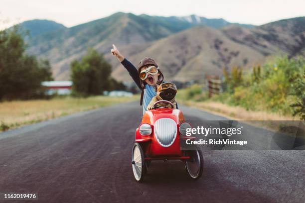 boy and dog in toy racing car - toy car stock pictures, royalty-free photos & images