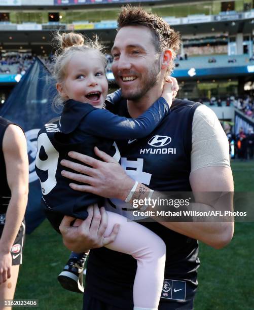 Dale Thomas of the Blues runs onto the field for his final match with his daughter during the 2019 AFL round 22 match between the Carlton Blues and...