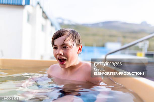 cute boy is cooling down in cold tub in iceland - cooling down stock-fotos und bilder