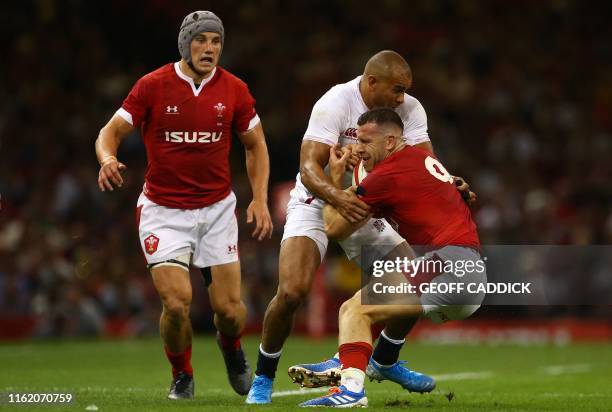 England's centre Jonathan Joseph tackles Wales' scrum-half Gareth Davies during the international Test rugby union match between Wales and England at...
