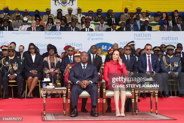 Gabon's President Ali Bongo and his wife Sylvia Bongo sit on the tribune as they attend a parade during the country's independence day celebration in...