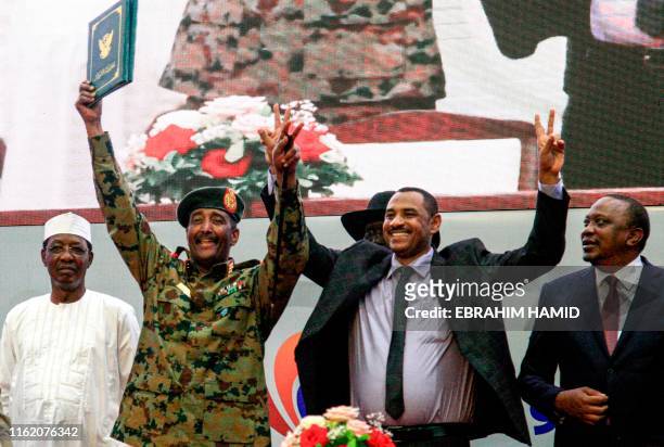 Sudan's protest leader Ahmad Rabie , flashes the victory gesture alongside General Abdel Fattah al-Burhan , the chief of Sudan's ruling Transitional...