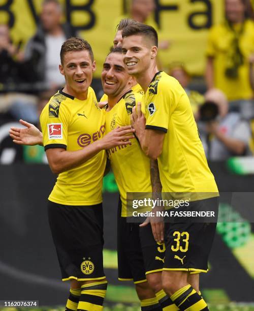 Dortmund's Spanish forward Paco Alcacer celebrates scoring with his team-mates Belgian forward Thorgan Hazard and German midfielder Julian Weigl...