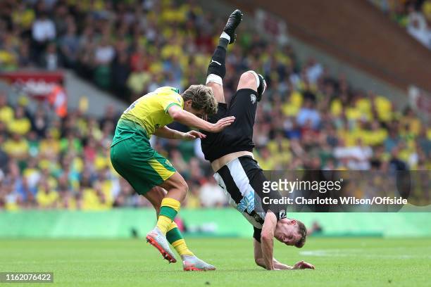 Emil Krafth of Newcastle comes crashing down to the ground after colliding with Todd Cantwell of Norwich during the Premier League match between...