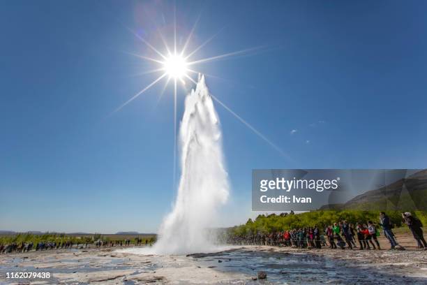strokkur geyser erupting with sunny shape, haukadalur valley area, iceland. - strokkur stock pictures, royalty-free photos & images