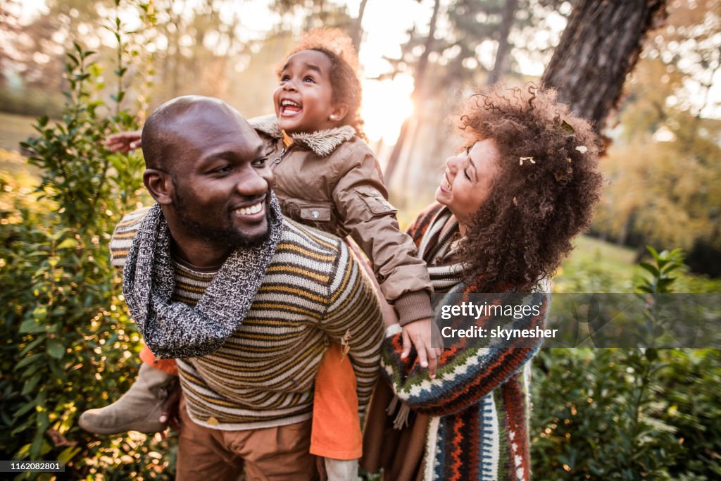 Glückliche schwarze Eltern, die Spaß mit ihrer Tochter im Park haben.