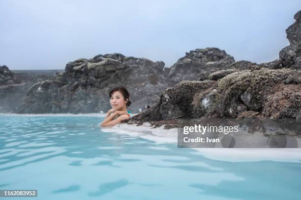 portrait of smiling asian young woman in hot spring - blue lagoon iceland stock-fotos und bilder