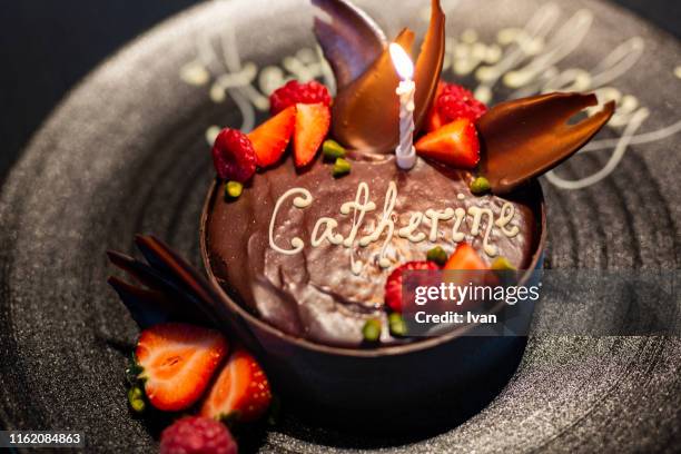 luxury fine dining, black chocolate birthday cake with red berry - birthday candle on black stock pictures, royalty-free photos & images