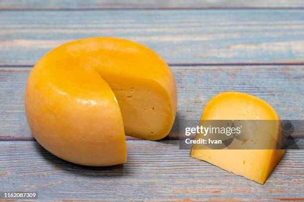 cheddar cheese and cheese pieces on wooden background - hartkäse stock-fotos und bilder