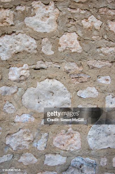 rustic stone wall made from limestone and concrete - limestone stock pictures, royalty-free photos & images
