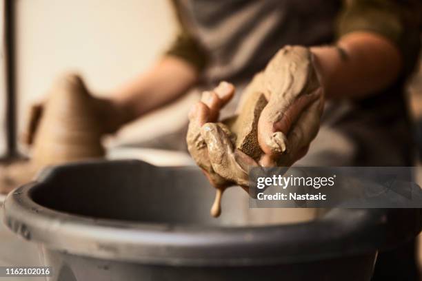 pottery maker using sponge for cleaning and making texture - potters wheel stock pictures, royalty-free photos & images