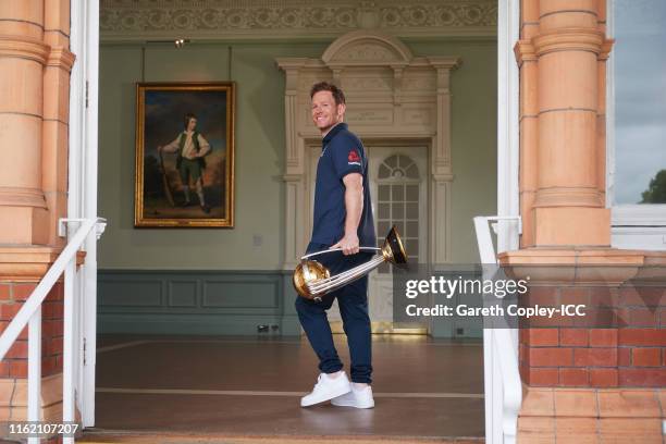 England captain Eoin Morgan poses with the trophy after the Final of the ICC Cricket World Cup 2019 between New Zealand and England at Lords Cricket...