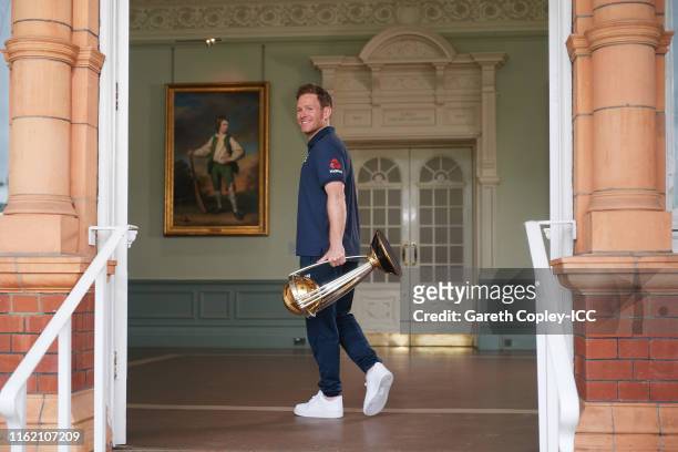 England captain Eoin Morgan poses with the trophy after the Final of the ICC Cricket World Cup 2019 between New Zealand and England at Lords Cricket...