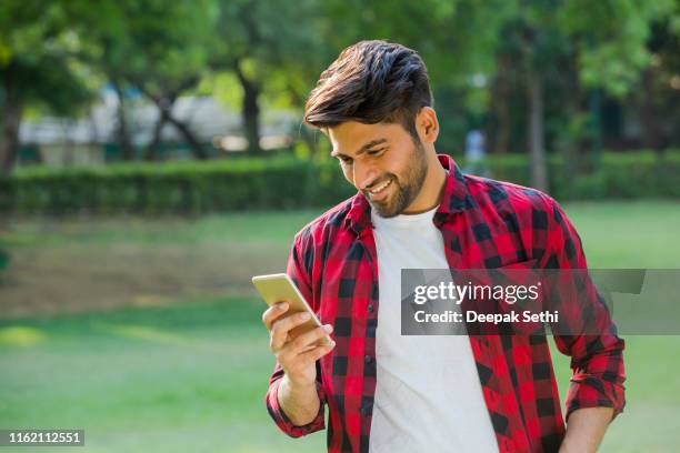 young man with mobile phone - stock images - handsome indian guys stock pictures, royalty-free photos & images