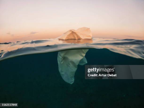 poetic view of plastic bag floating in the sea like iceberg. - plastic bag stock pictures, royalty-free photos & images