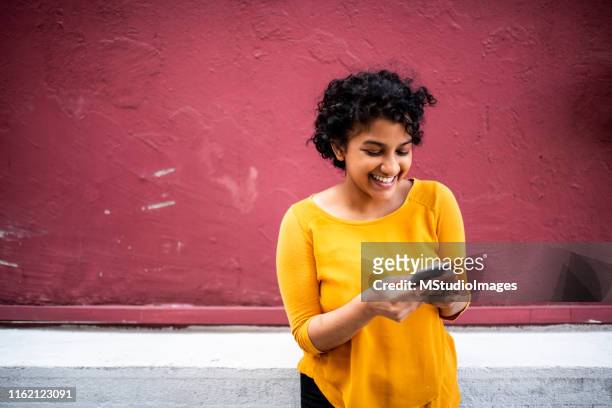 lachende indiase vrouw met behulp van mobiele telefoon - call us stockfoto's en -beelden
