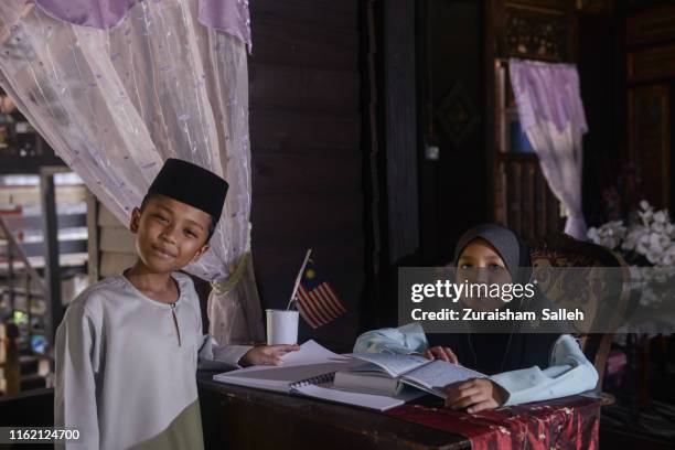 malaysian children in traditional costume at home - koran stock pictures, royalty-free photos & images