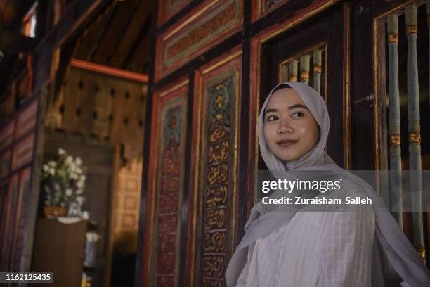 portrait of malaysian muslim woman in hijab at traditional malay house - malaysia batik stock pictures, royalty-free photos & images