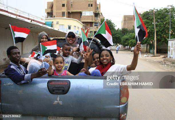 Sudanese children wave small national flags as people celebrate outside the Friendship Hall in the capital Khartoum where generals and protest...