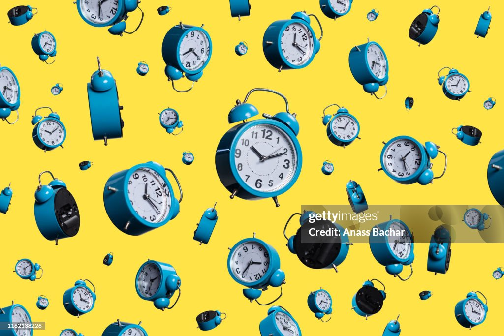 Full Frame Shot Of Alarm Clocks On Yellow Background