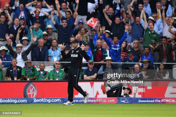 Martin Guptill of New Zealand immediately signals a six after team mate Trent Boult of New Zealand trod on the boundary after taking a catch from Ben...