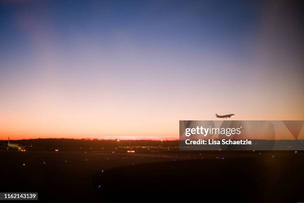 aircraft flying at the sunrise sky - frankfurter flughafen stock-fotos und bilder