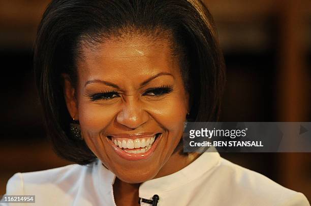 First Lady Michelle Obama smiles as she speaks with students from the Elizabeth Garrett Anderson School during a visit to Christ Church College at...