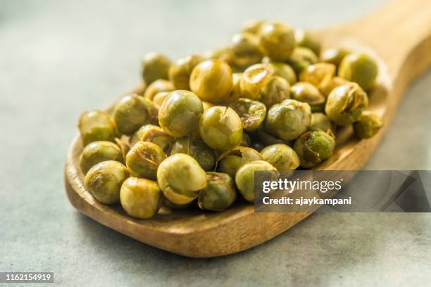 indian snacks : spicy fried green peas - green pea stock pictures, royalty-free photos & images