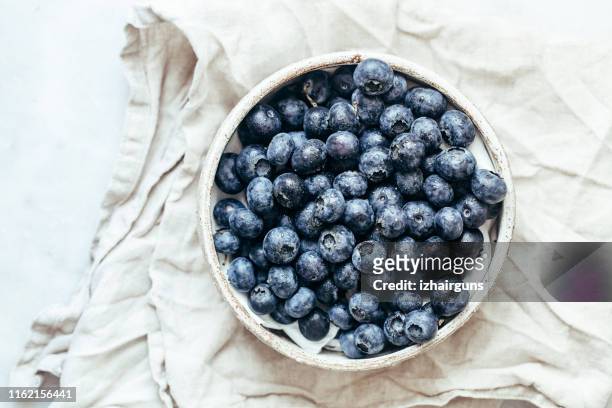 heidelbeerschale auf weißem hintergrund mit kopierraum im rustikalen stil - blueberries stock-fotos und bilder
