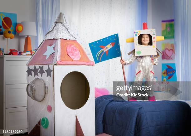 young girl playing astronaut with cardboard rocket - new jersey rockets stock pictures, royalty-free photos & images