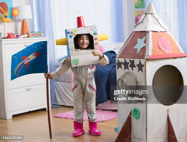 young girl playing astronaut with cardboard rocket - kidstock girl stock pictures, royalty-free photos & images